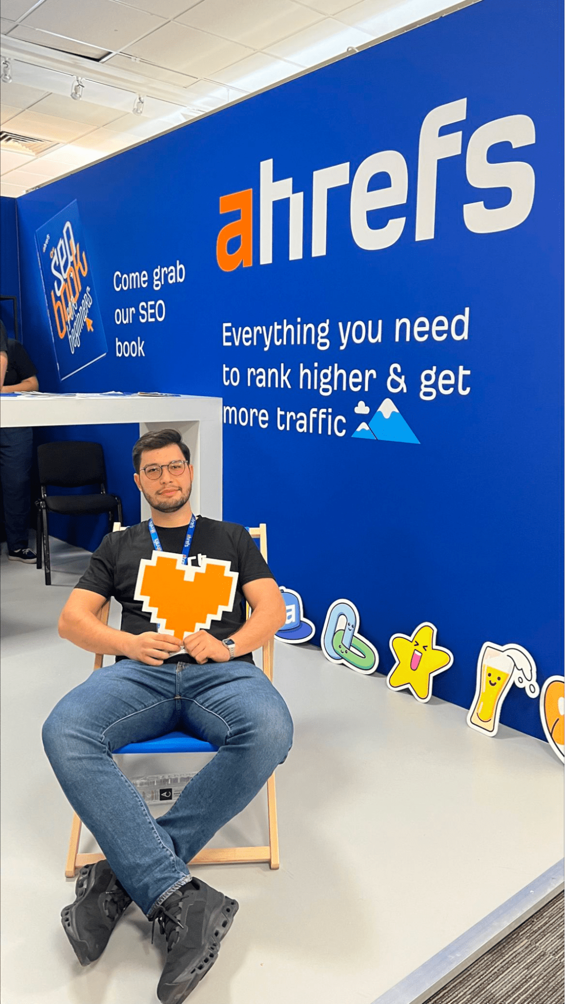 Andrei Țiț se détend sur une chaise au stand des exposants d'Ahrefs