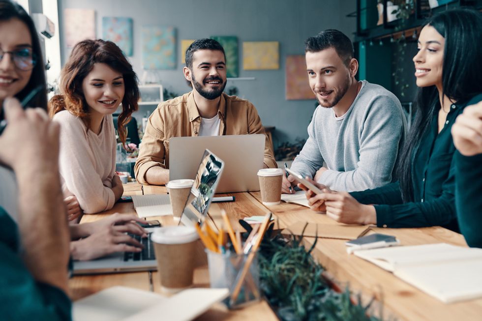 Groupe de jeunes professionnels établissant des relations entre eux et gagnant la confiance lors d'une réunion d'affaires