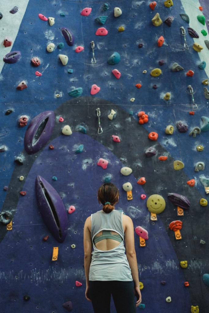 Femme devant un mur d'escalade