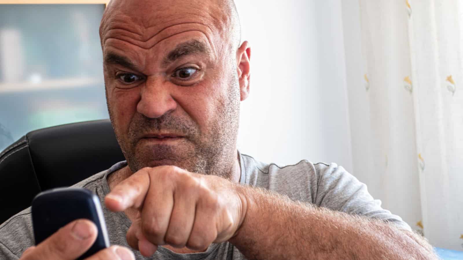 homme en colère pointant le téléphone