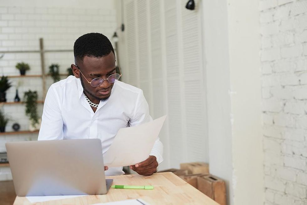 Un homme regarde sa lettre de motivation devant son ordinateur portable