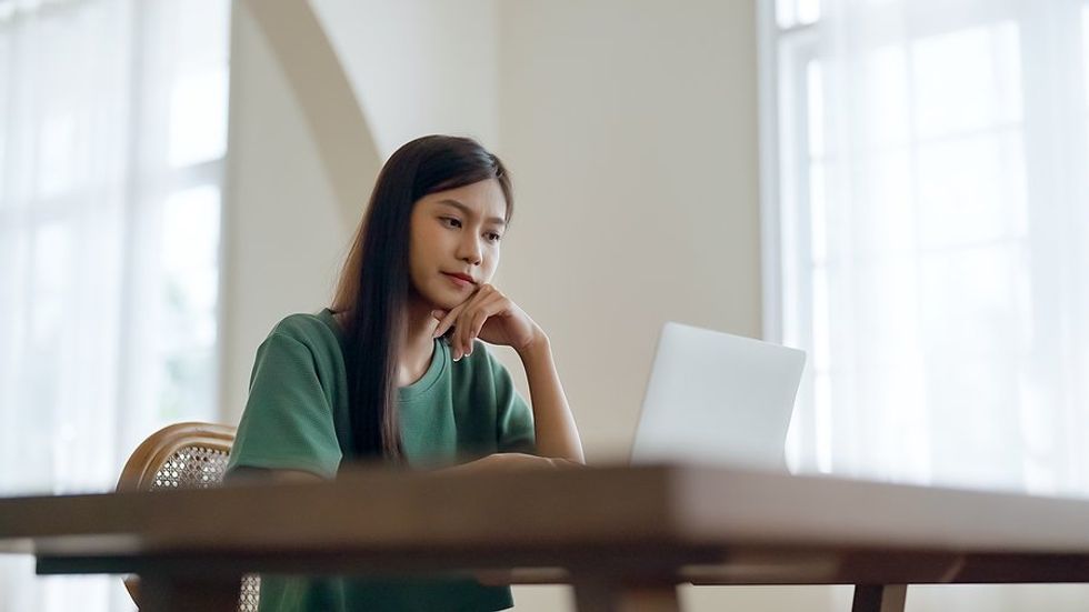 Une jeune femme/récente diplômée possédant un ordinateur portable postule pour un emploi