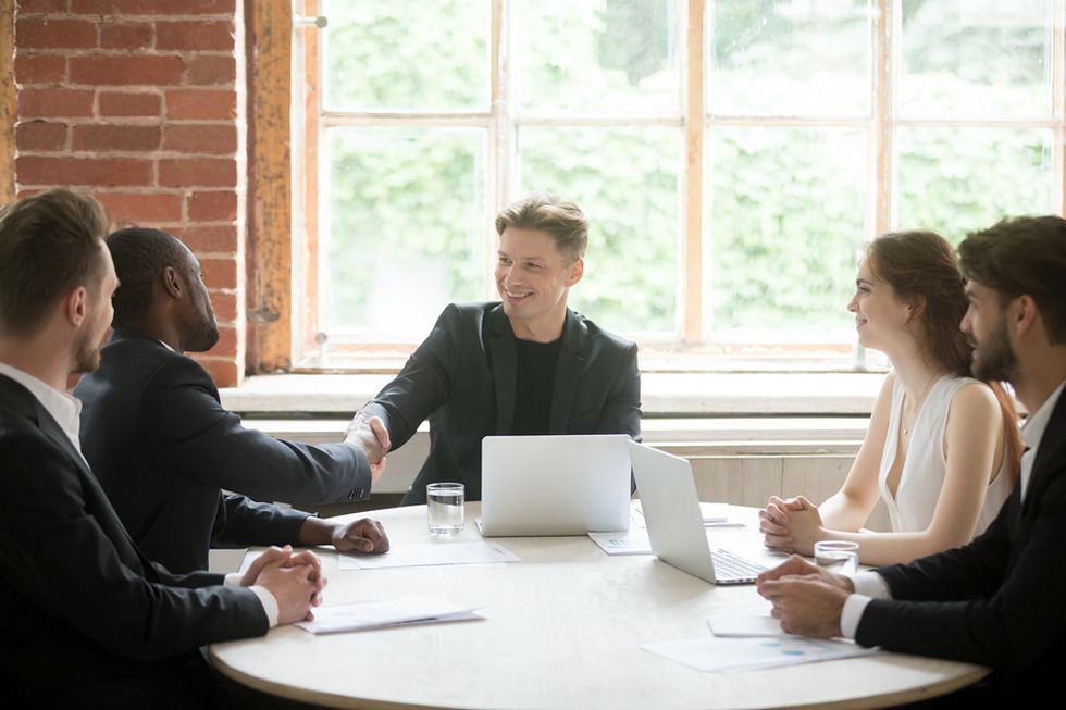 Patron/leader masculin voyant une situation gagnant-gagnant lors d'une réunion d'équipe au travail