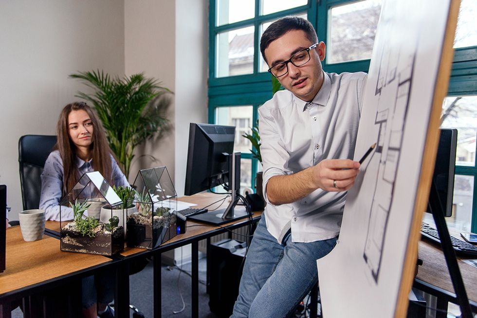 Un homme qui montre qu'il est prêt à assumer plus de responsabilités au travail en menant un projet difficile et en faisant une présentation